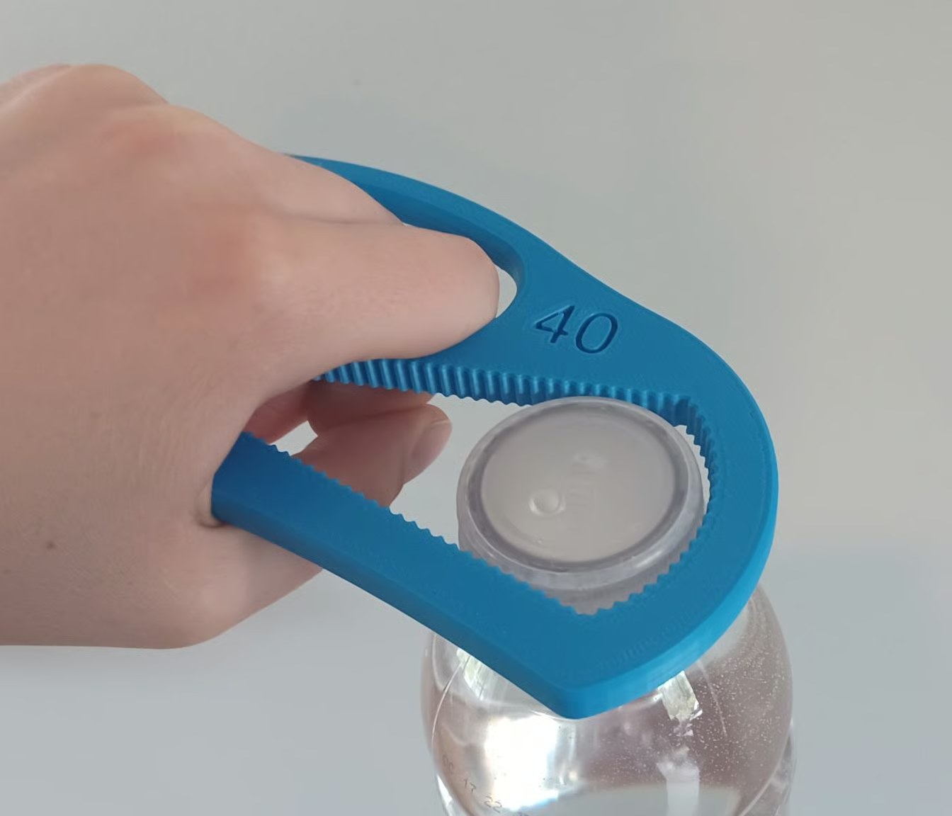 A blue 3D printed bottle opener gripping a water bottle cap