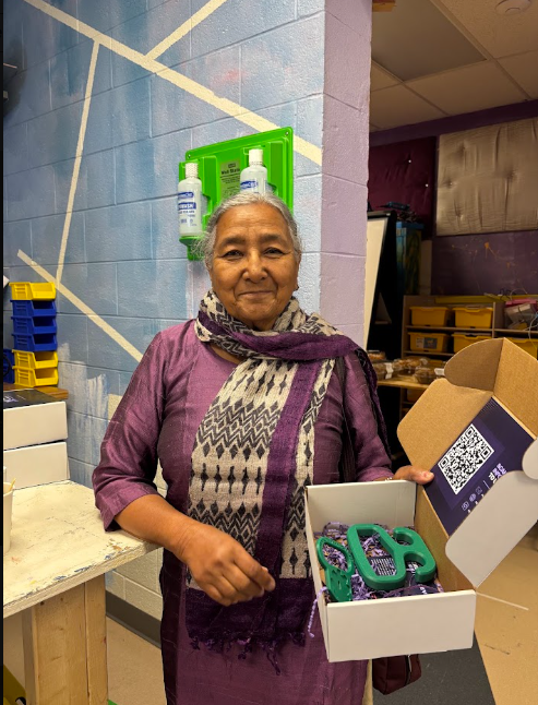 A community member with an open MNDX box holding assistive devices