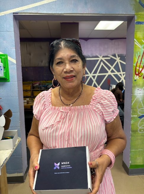 A community member holding her MNDX device box
